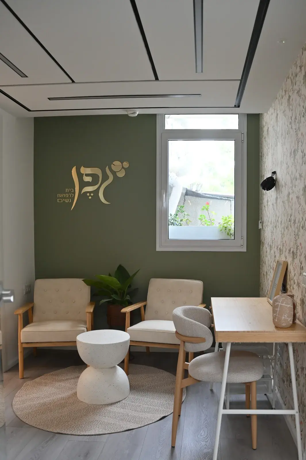 חדר ההמתנה במרפאת גפן — כורסאות, שולחן וטפט פרחוני
